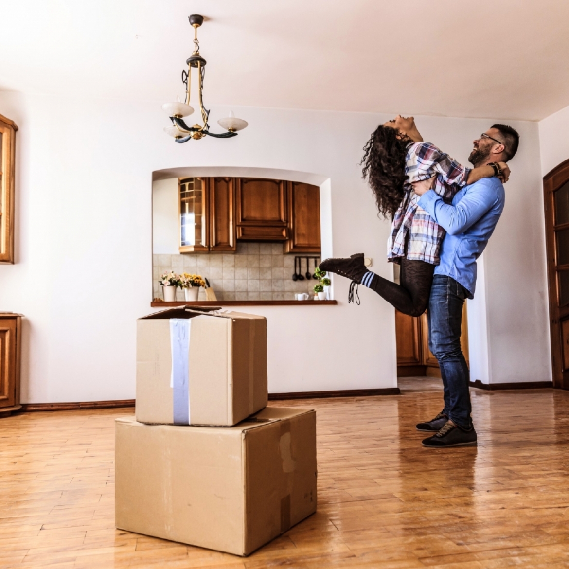 Image of man picking up woman and both smiling happily 
